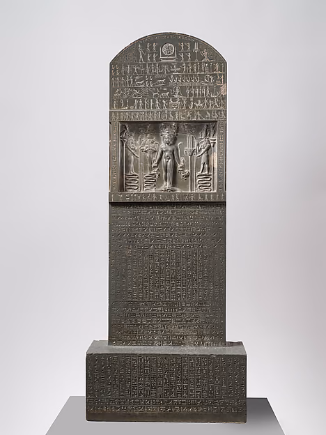 The Metternich Stela, the slab that carries the story. The child Horus stands in the carved panel at the top.